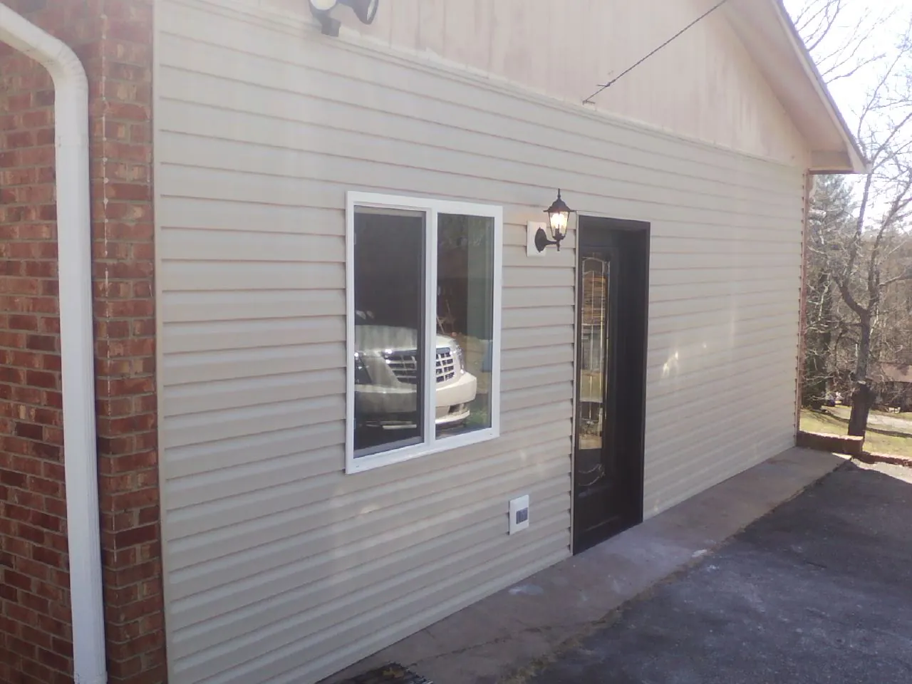 New vinyl siding and entry door on a room addition in Rockford