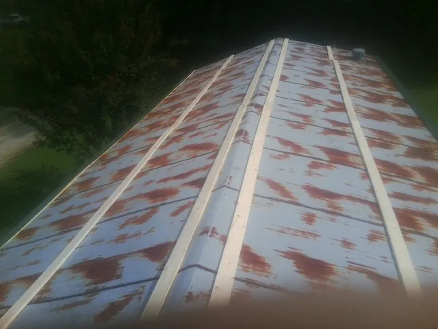Rusted metal roof panels with new wood purlins before replacement — Storm Damage Roof Repair in Rockford by Roofing Brothers